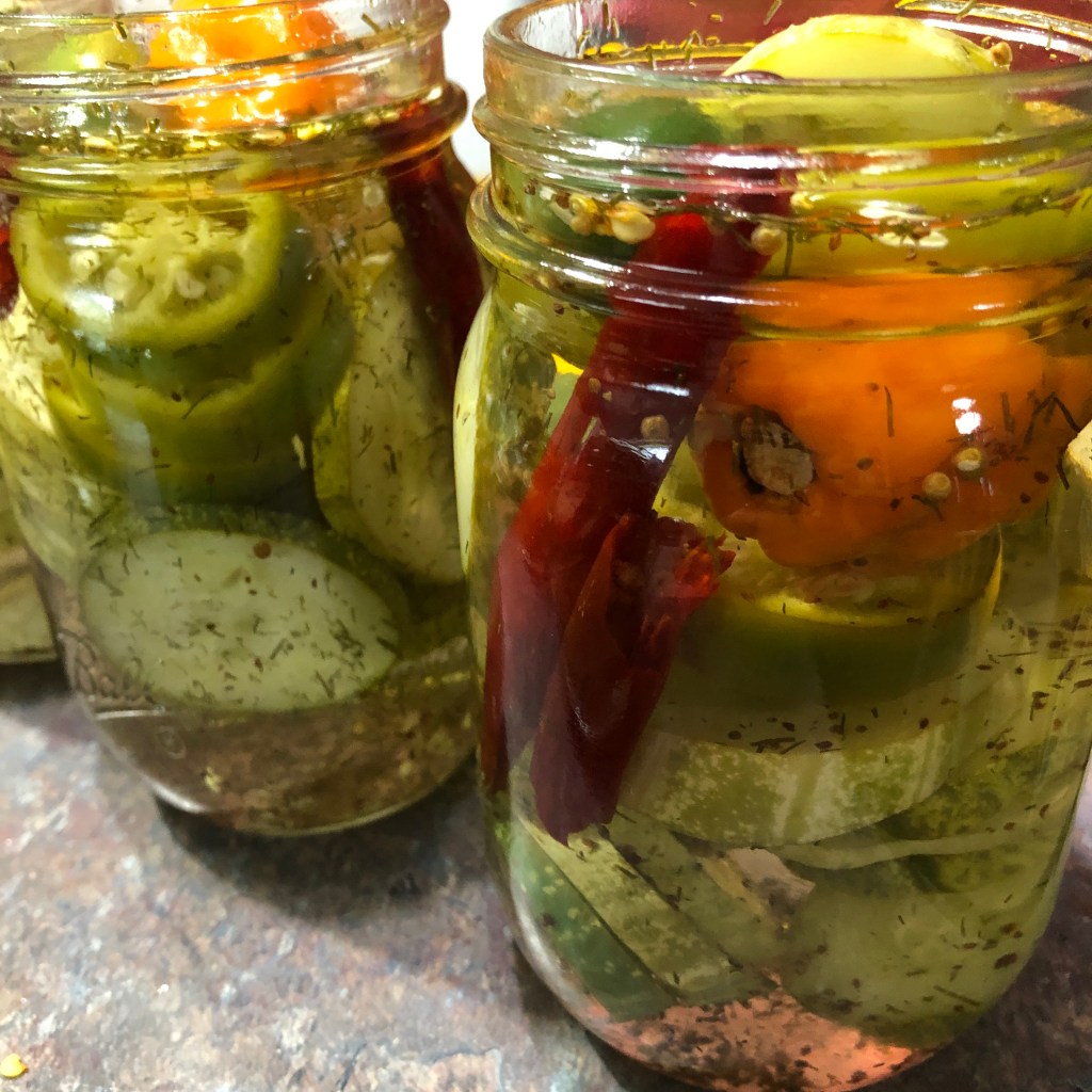 Pickled cucumbers and peppers in jars 